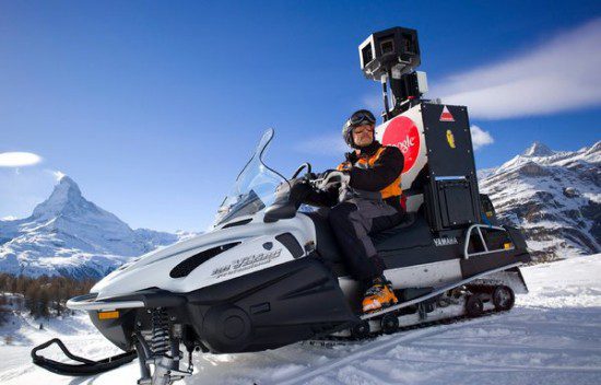 a man on a snowmobile capturing footage with a camera attached to it, while adhering to online privacy rules.