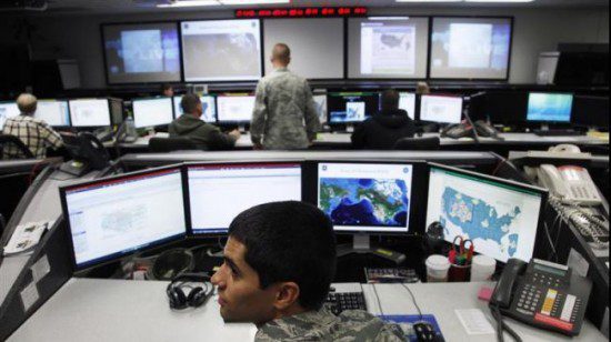 a man is sitting at a desk with several monitors while overseeing security operations related to iran and its middle east allies.