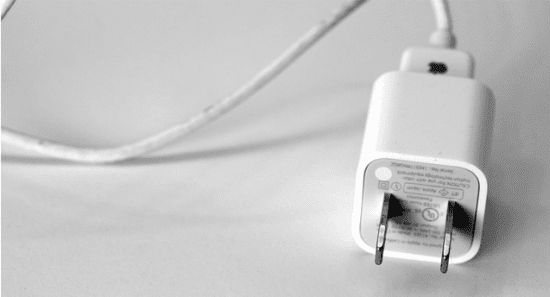 a black and white photo of an iphone charger.